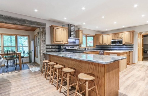 Waupaca House | A beautiful recently remodeled home nested on a wooded river lot with a hot tub.