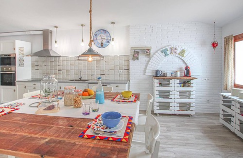 El Vendrell House | A large cottage with bright interior and private outdoor pool, next to a covered terrace.