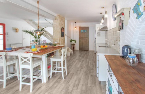 El Vendrell House | A large cottage with bright interior and private outdoor pool, next to a covered terrace.