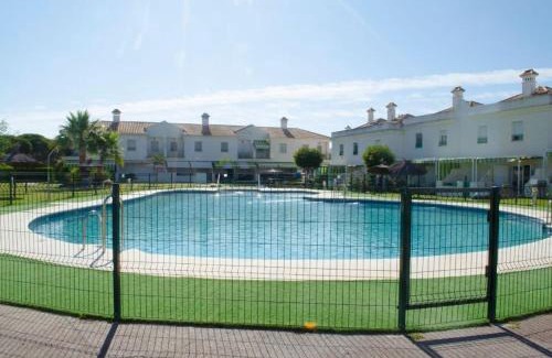 El Portil Apartment | Casa adosada con porche, piscina y pista de pádel, junto al campo de golf