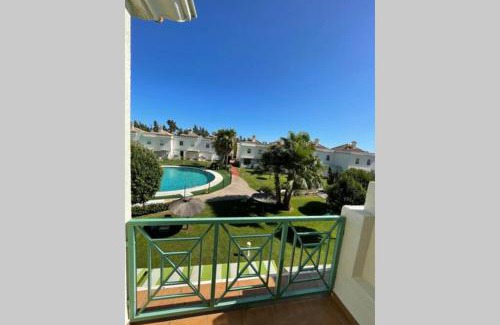 El Portil Apartment | Casa adosada con porche, piscina y pista de pádel, junto al campo de golf