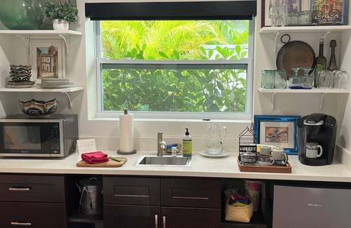 Parrot Cove Cottage | Chill on the patio overlooking the pool & lush gardens with privacy!