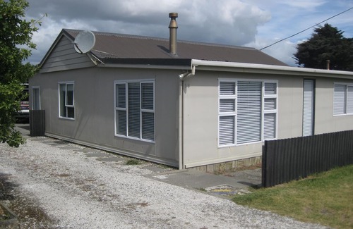 Waitarere Beach House | HAPPY HAVEN has Kiwi Bach character with location.