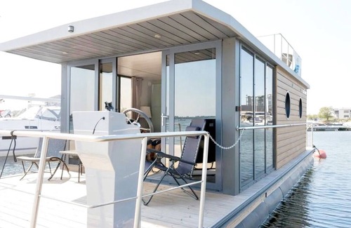 Flensburg Boat Rental | Houseboat Luv in Sonwik harbor with a view of Denmark