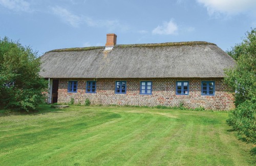 Tim House | In the countryside and surrounded by fields lies this idyllic farmhouse with a thatched roof.