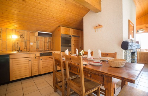 Verbier Apartment | Living room with fireplace, open-plan kitchen with dishwasher, eating corner, two bedrooms with 2 be