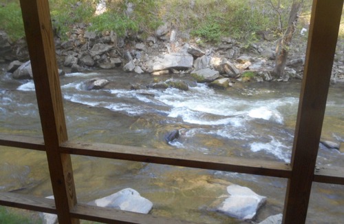 Bat Cave Cottage | On the River's Edge! Rocking chairs on large screened porch on river's edge.