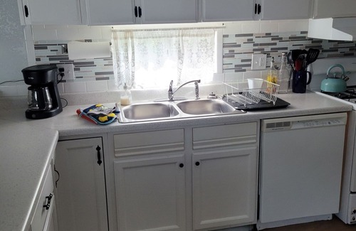 Kiteley House | Spacious mobile home with large kitchen/living area and porch with barbeque.