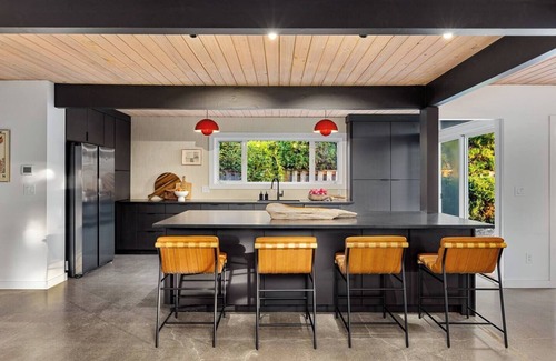 Oak Hills House | This Robert Rummer masterpiece celebrates mid-century design and A. Quincy Jones’ iconic “double gable.” Soak in natural light from the atrium, relax under vaulted ceilings, and retreat to your private hot tub where style and serenity meet.