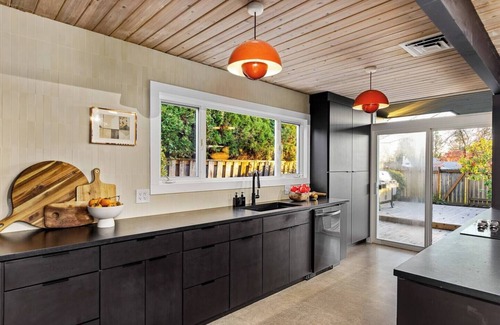 Oak Hills House | This Robert Rummer masterpiece celebrates mid-century design and A. Quincy Jones’ iconic “double gable.” Soak in natural light from the atrium, relax under vaulted ceilings, and retreat to your private hot tub where style and serenity meet.