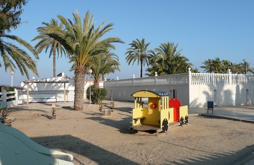 El Algar Villa | View of the sea and the private garden with palm trees and an olive tree.
