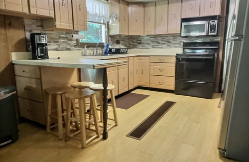 Brookville House | Welcome to your perfect getaway! Nestled on a semi-secluded 2-acre lot, this charming brick Cape Cod is centrally located between Cook Forest and Clear Creek State Parks. Surrounded by trees, this cozy retreat offers a peaceful escape.