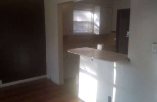 Detroit House | White bungalow style house with a fenced yard and at a walking distance to shopping centers