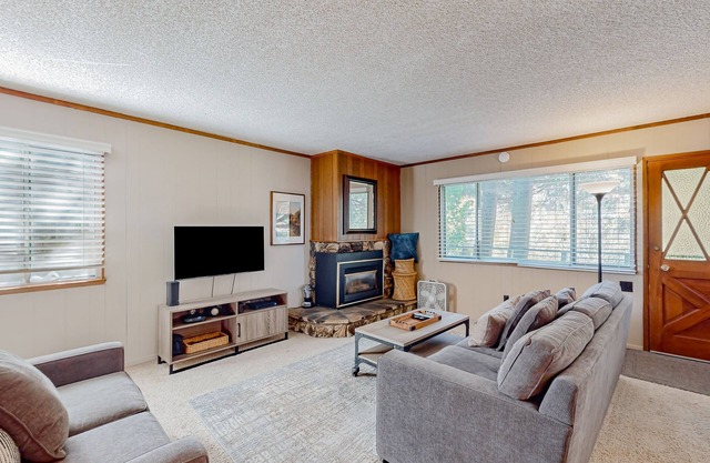Classic central cabin near river with large tree-lined deck, grassy yard & gym
