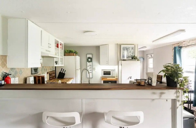 Cozy home with butcher block counter tops, custom live-edge walnut bar top