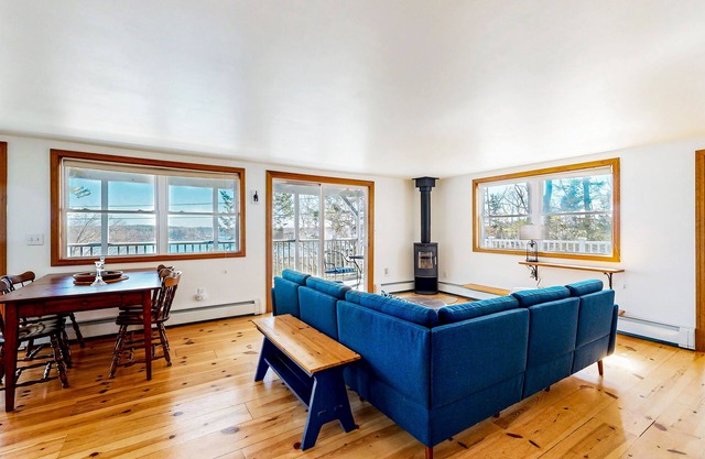 Dog-friendly river-view home with wood stove, deck, patio, dock, beach, grill