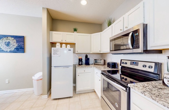 Golf course-view townhouse with hot tub, outdoor pool, golf, balcony, W/D, & AC