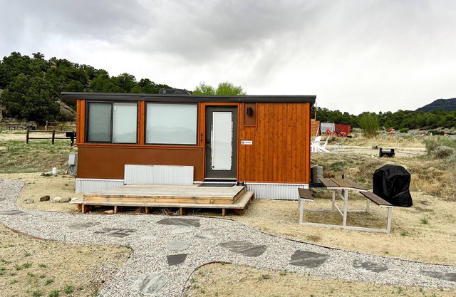Oxford is a one-level 1-2 person Tiny Home with full bathroom, fridge, induction cooktop, microwave, AC/heat, dryer/washer combo, and beautiful mountain views!