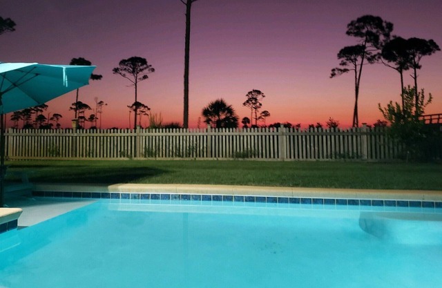 Summer Bay, a beautiful Bay View Home private backyard oasis around the swimming pool, screened porch, and sundeck