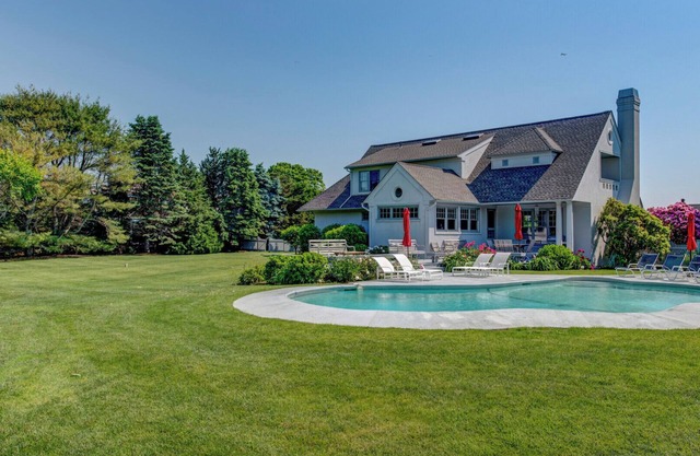 Traditional-style home with private pool, sweeping back deck, grand lawn,.