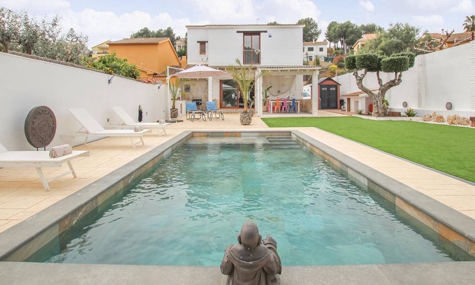 El Vendrell House | A large cottage with bright interior and private outdoor pool, next to a covered terrace.