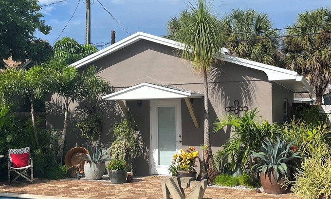 Parrot Cove Cottage | Chill on the patio overlooking the pool & lush gardens with privacy!