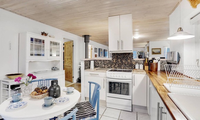 Ordrup House | Classic vacation home with inviting eat-in kitchen, wood-burning stove, TV room and 3 bedrooms.