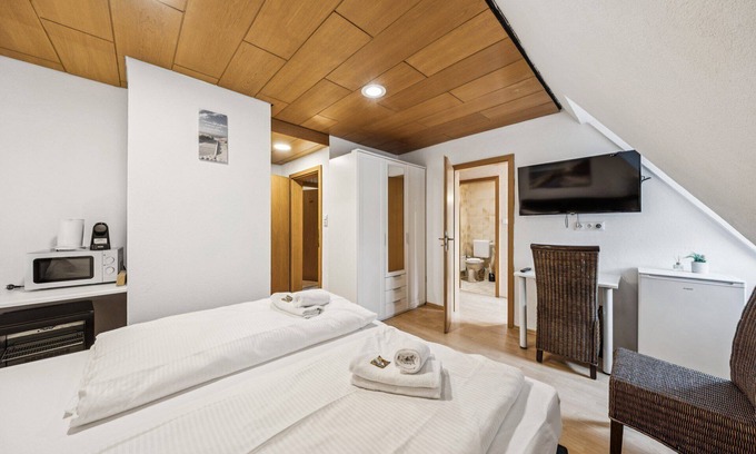 Wilhelmshaven Hotel | Comfortable room with a double and single bed, private bathroom, flat-screen TV, fridge, microwave, coffee machine, and cozy seating area. Ideal for small families or friends traveling together.