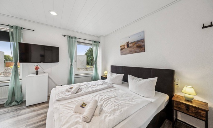 Wilhelmshaven Hotel | Cozy double room, flat-screen TV, and modern bathroom with shower. Ideal for couples and short stays – enjoy a relaxed atmosphere with warm wood accents and coastal charm.