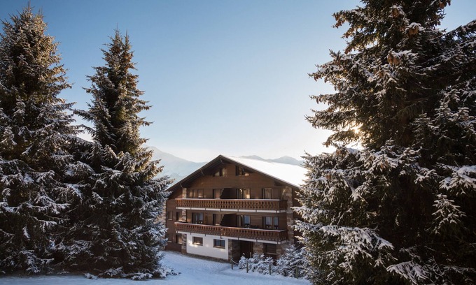 Verbier Apartment | Living room with fireplace, open-plan kitchen with dishwasher, eating corner, two bedrooms with 2 be
