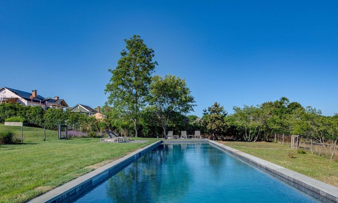Eastport House | Modern-style home with a private pool, vast back lawn, several sitting...