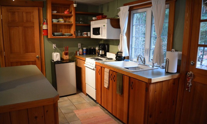 Ashford Cabin | This romantic cabin at Mt. Rainier is a one room cabin with private hot tub right on Copper Creek. It has a queen bed and a queen Murphy bed. Walk to Copper Creek Restaurant. Beautiful woodland setting.